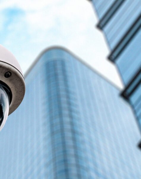 Security camera with a glass building on the background on the street